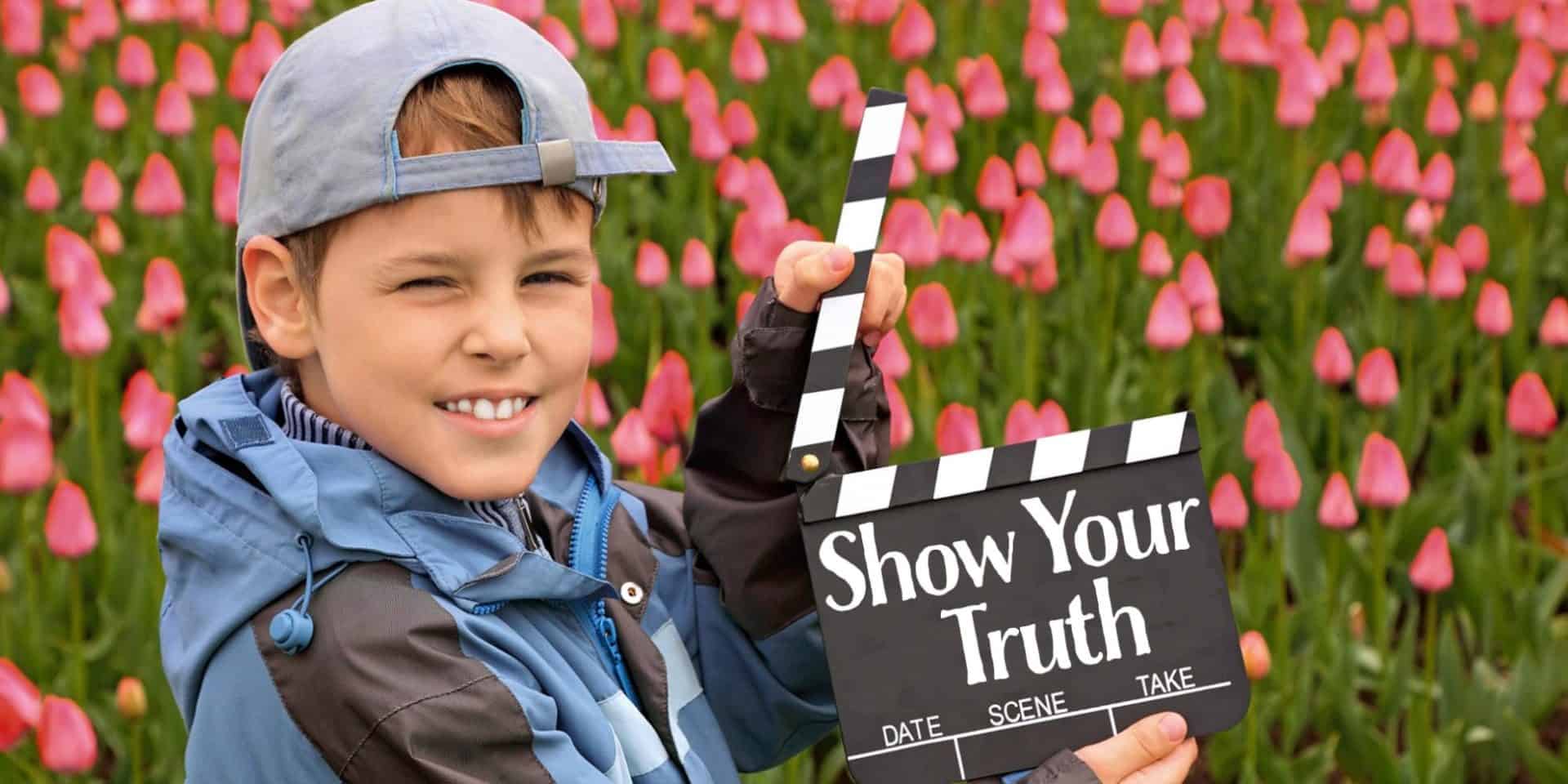 Boy in jacket and cap with cinema clapper board in their hands s
